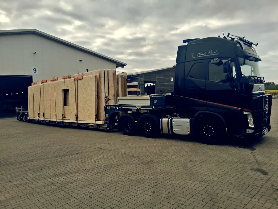 Black Pearl Volvo FH mit Fertighaus-Wandelementen auf dem Auflieger