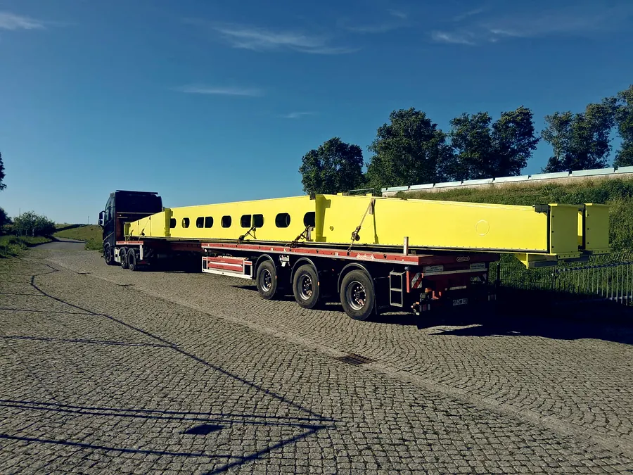 Volvo Sattelzug mit langem gelben Stahlträger als Schwertransport